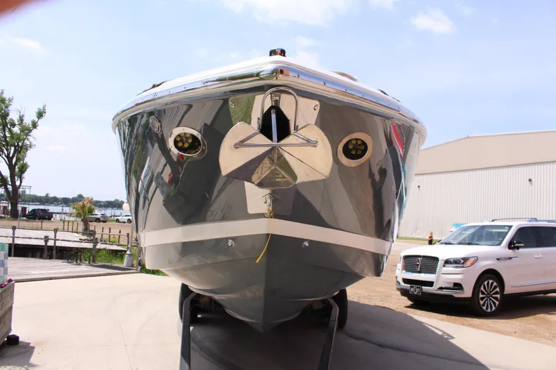 Slide: The Image of 2021 Cobalt R35 Surf boat on trailer, front view, near waterfront and parked vehicles. - 29