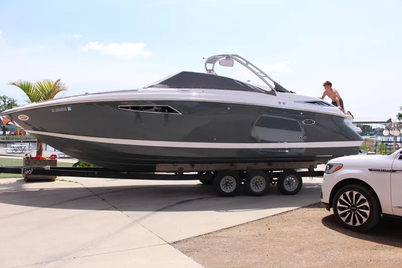 Slide: The Image of 2021 Cobalt R35 Surf boat on trailer beside a white vehicle, outdoors. - 31