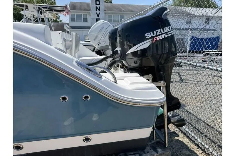Slide: The Image of 2007 Sea Fox 256 boat with Suzuki outboard motor, parked near a chain-link fence. - 11