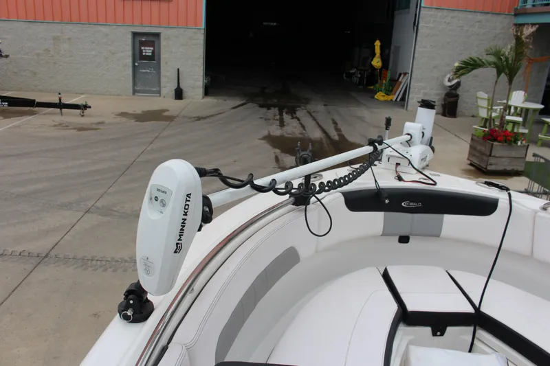 Slide: The Image of 2021 Robalo 222EX boat with Minn Kota trolling motor in a marina setting. - 5