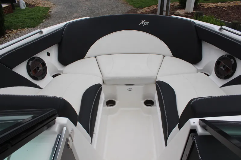 Slide: The Image of 2018 MasterCraft XT22 boat interior with black and white seating and built-in speakers. - 13