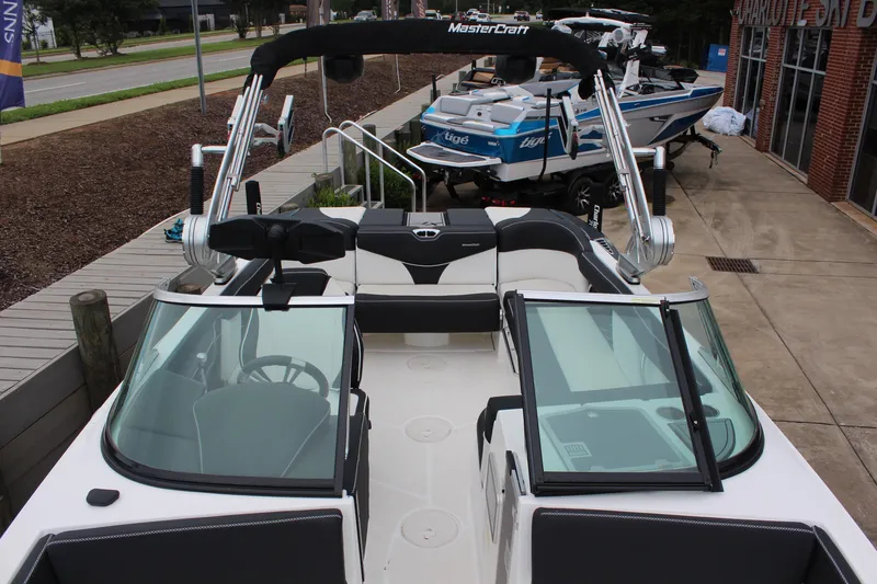 Slide: The Image of 2018 MasterCraft XT22 boat with sleek design, parked near a showroom. - 14