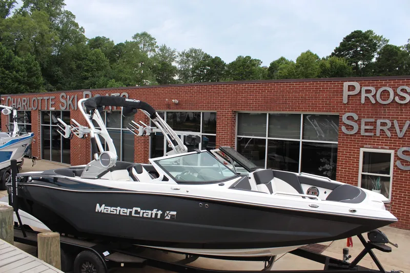 Slide: The Image of 2018 MasterCraft XT22 boat displayed outside a brick building. - 2