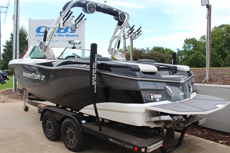 Slide: The Image of 2018 MasterCraft XT22 boat on trailer, displayed outdoors at a dealership. - 5