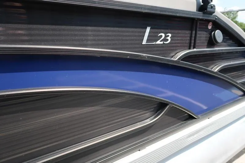 Slide: The Image of 2022 Bennington 23 LSB boat side view with sleek design and blue accent. - 12