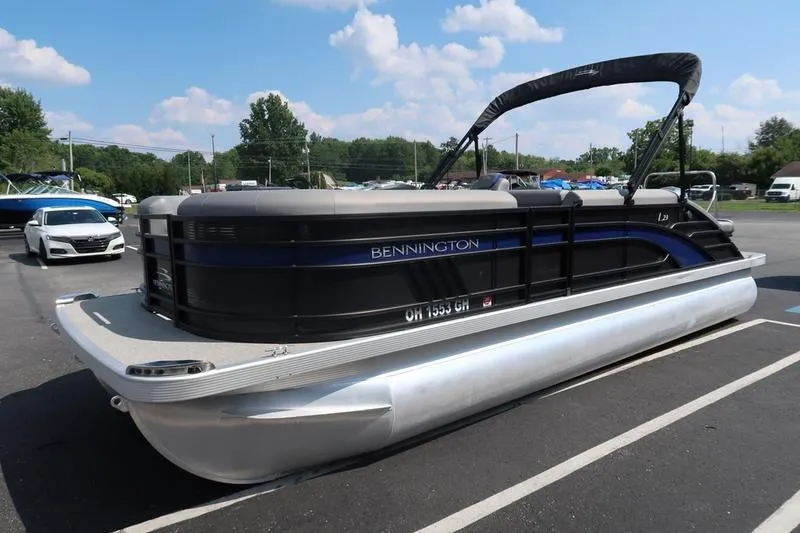 Slide: The Image of 2022 Bennington 23 LSB pontoon boat parked in a lot under a clear sky. - 7