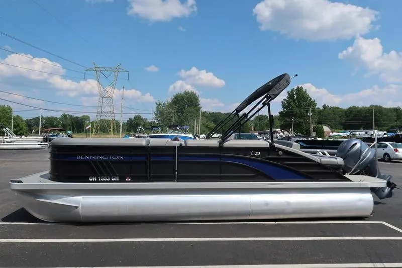 Slide: The Image of 2022 Bennington 23 LSB pontoon boat parked under a clear blue sky. - 8