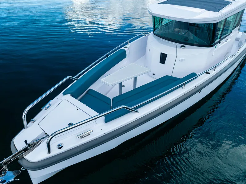 Slide: The Image of 2022 Axopar 28 boat on calm water, featuring sleek design and spacious seating. - 14
