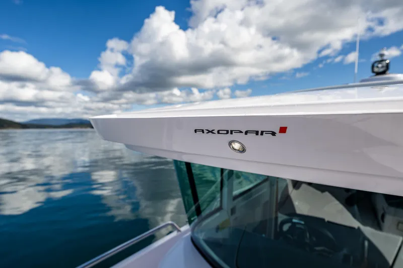 Slide: The Image of 2022 Axopar 28 boat on calm water under a cloudy sky. - 23