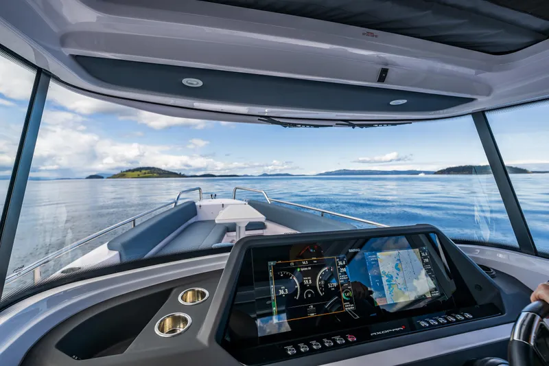 Slide: The Image of Interior view of 2022 Axopar 28 boat with navigation display, cruising on calm waters. - 25
