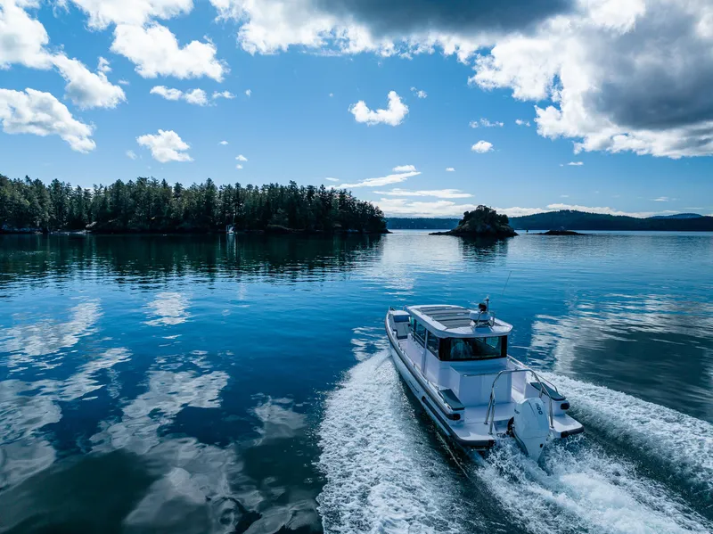 Slide: The Image of 2022 Axopar 28 cruising on a serene lake under a blue sky. - 4