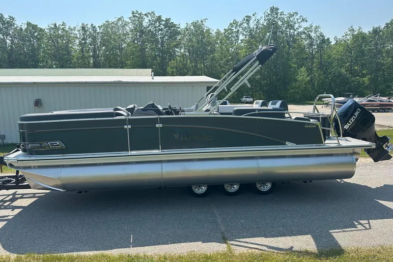Slide: The Image of 2025 Tahoe 2385 pontoon boat with Suzuki outboard motor, parked outdoors. - 1