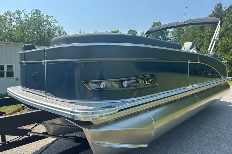 Slide: The Image of 2025 Tahoe 2385 pontoon boat on trailer, sleek design, sunny day background. - 2