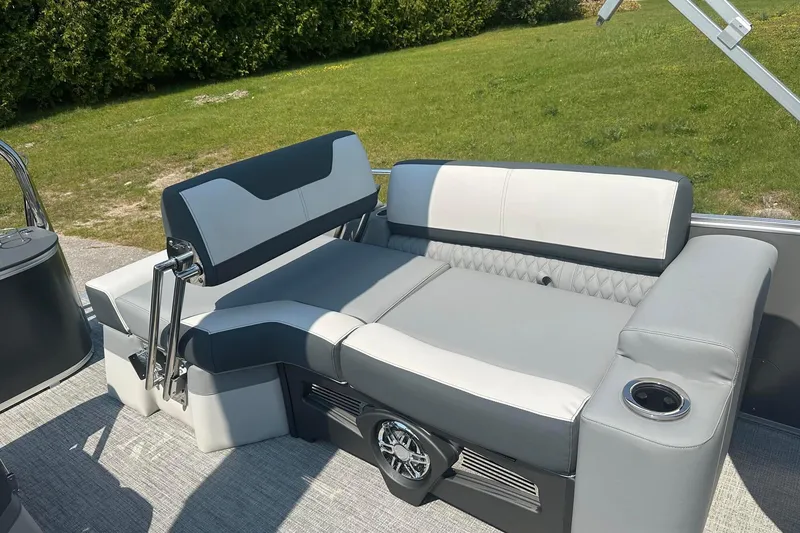 Slide: The Image of 2025 Tahoe 2385 boat interior with gray and white seating, cup holder, and speaker. - 23