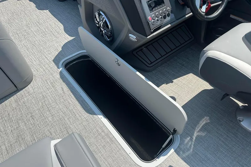 Slide: The Image of 2025 Tahoe 2385 boat interior with open storage compartment and modern dashboard. - 25