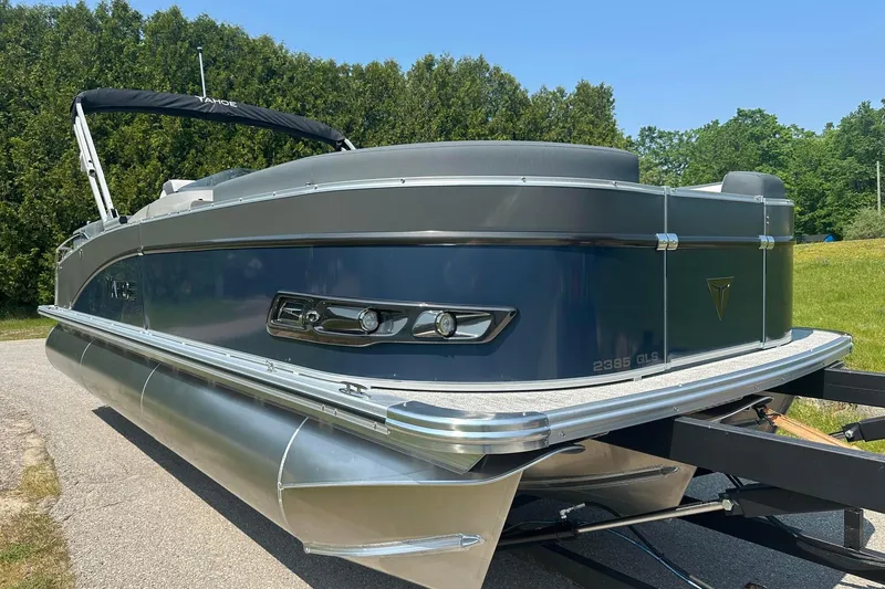 Slide: The Image of 2025 Tahoe 2385 pontoon boat on trailer, sleek design, parked outdoors. - 4