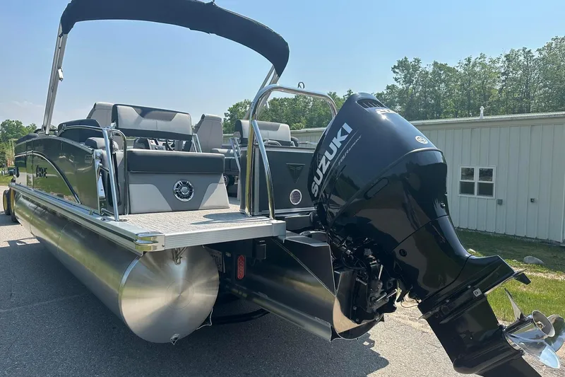Slide: The Image of 2025 Tahoe 2385 pontoon boat with Suzuki outboard motor, parked outdoors. - 8