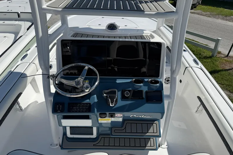 Slide: The Image of 2026 Tidewater 2500 Carolina Bay boat console with steering wheel and controls. - 10