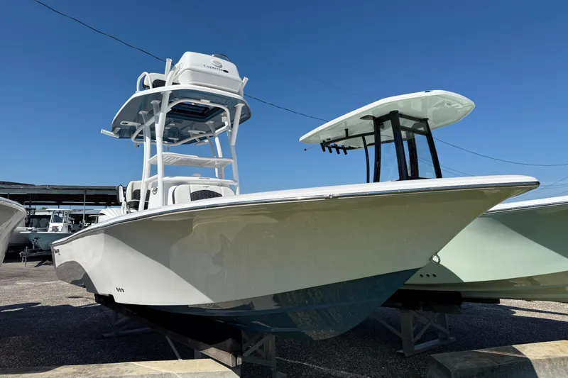 Slide: The Image of 2026 Tidewater 2500 Carolina Bay boat displayed outdoors under clear blue sky. - 17