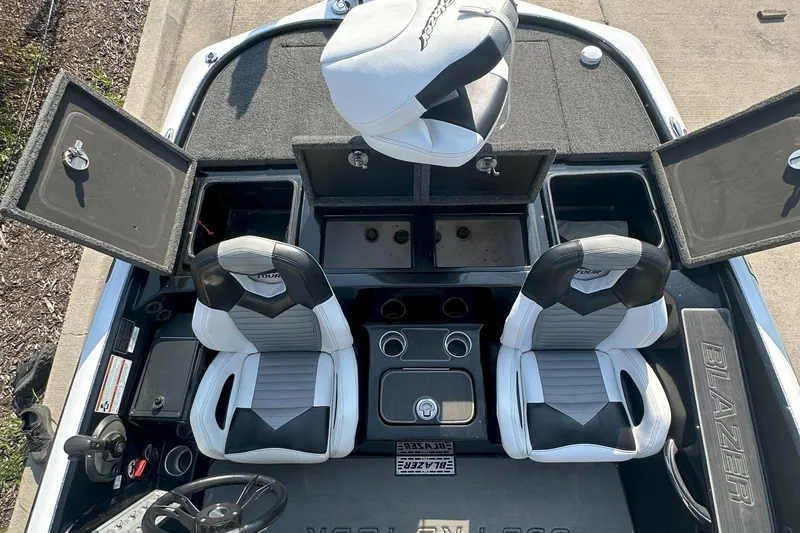 Slide: The Image of 2021 Blazer 650 Pro Tour boat interior with open storage compartments and dual seats. - 18