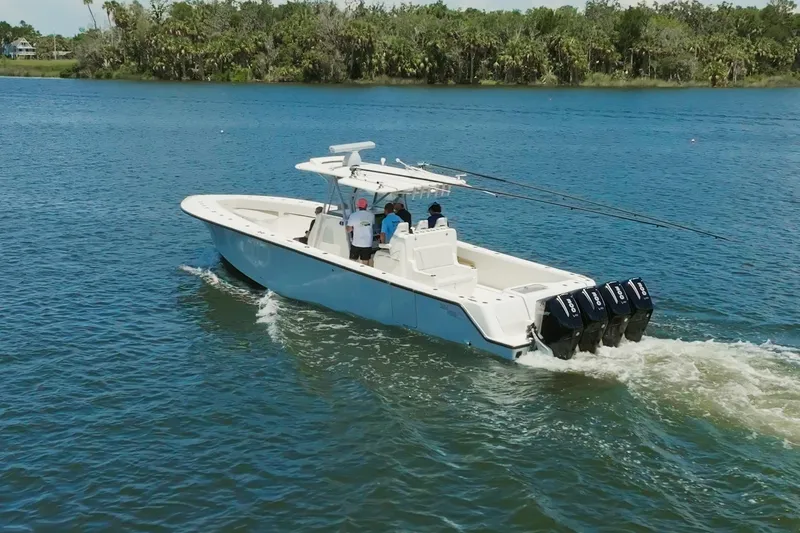 Slide: The Image of 2021 SeaVee 390Z boat cruising on a scenic lake with lush greenery. - 12