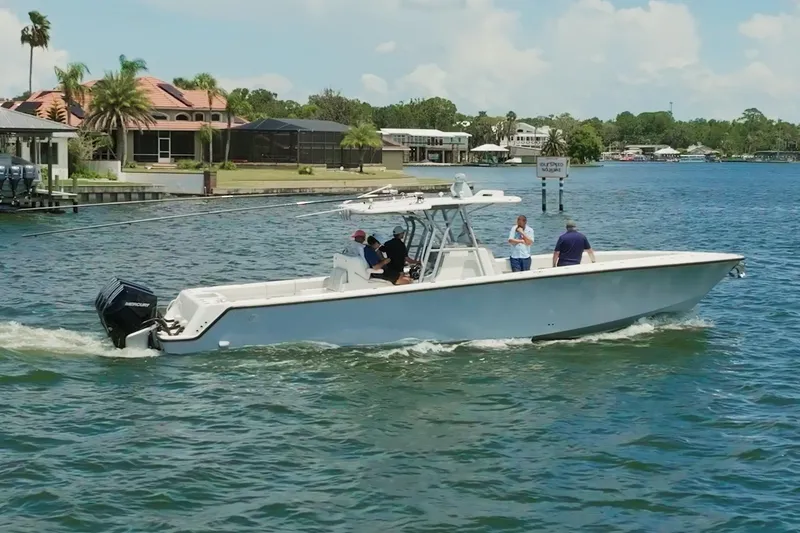 Slide: The Image of 2021 SeaVee 390Z boat cruising on a sunny day near waterfront homes. - 13