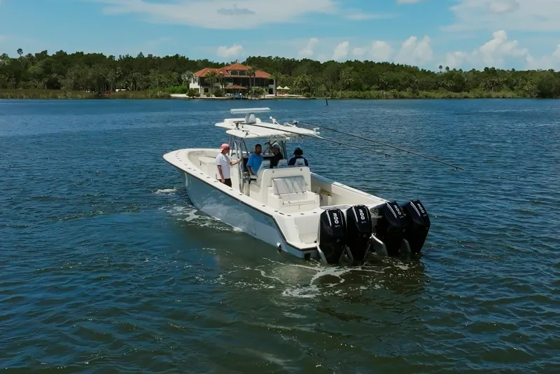Slide: The Image of 2021 SeaVee 390Z boat cruising on a lake with multiple outboard engines. - 9
