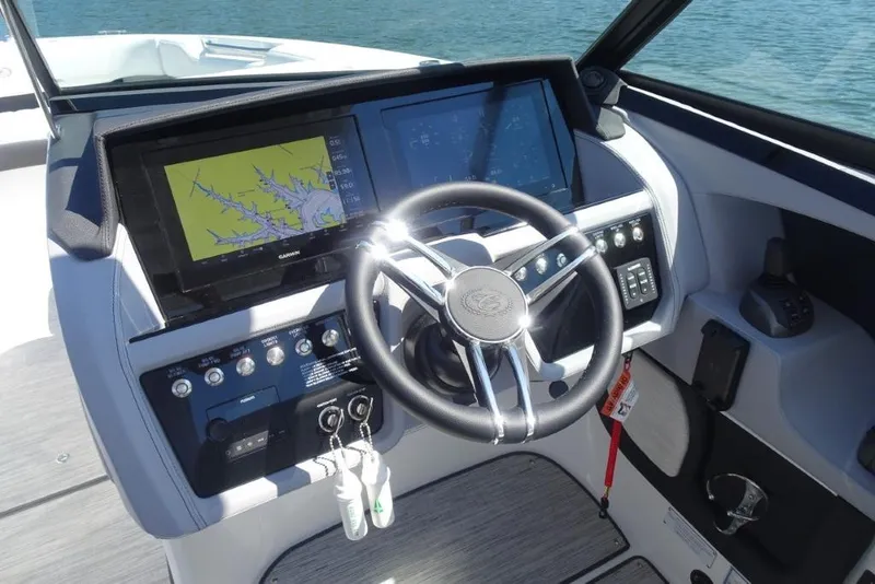 Slide: The Image of 2025 Cobalt R30 boat dashboard with advanced navigation screens and steering wheel. - 12
