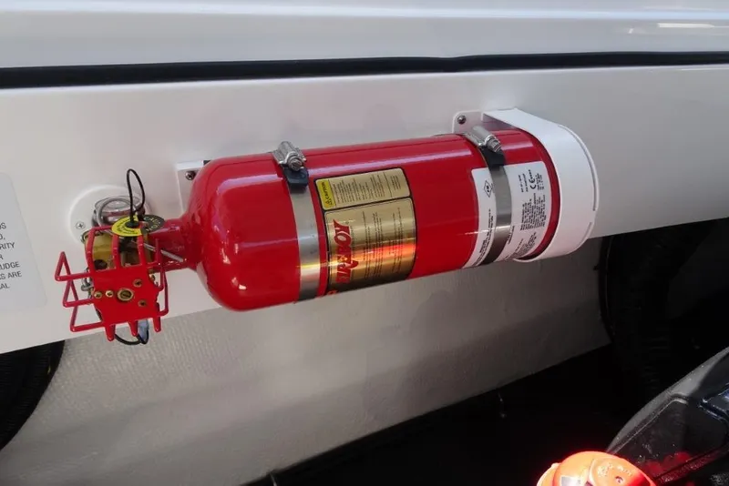 Slide: The Image of Red fire extinguisher mounted on a 2025 Cobalt R30 boat interior. - 25