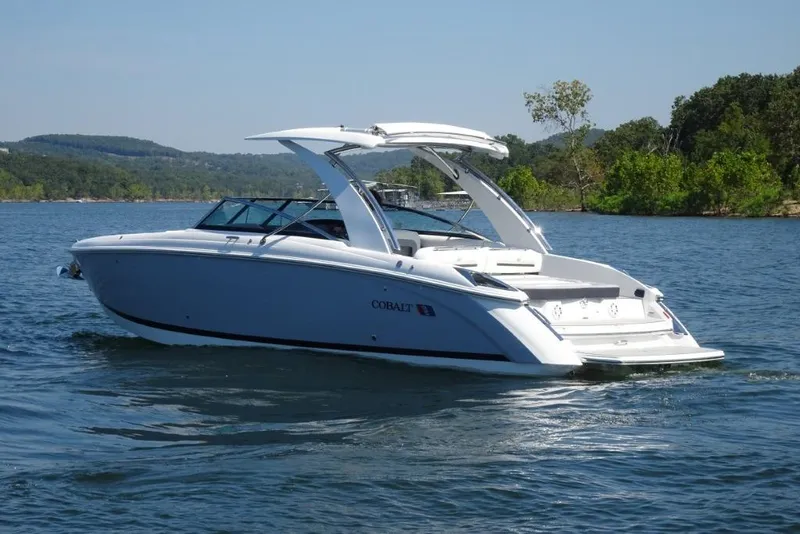 Slide: The Image of 2025 Cobalt R30 boat cruising on a scenic lake with lush green surroundings. - 4