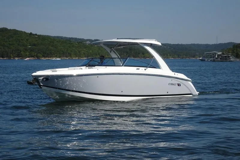 Slide: The Image of 2025 Cobalt R30 boat cruising on a scenic lake with lush green hills. - 6