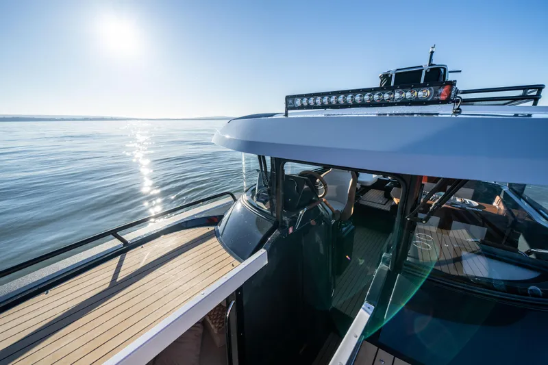 Slide: The Image of 2023 Arksen 30 boat on calm water under clear blue sky. - 27