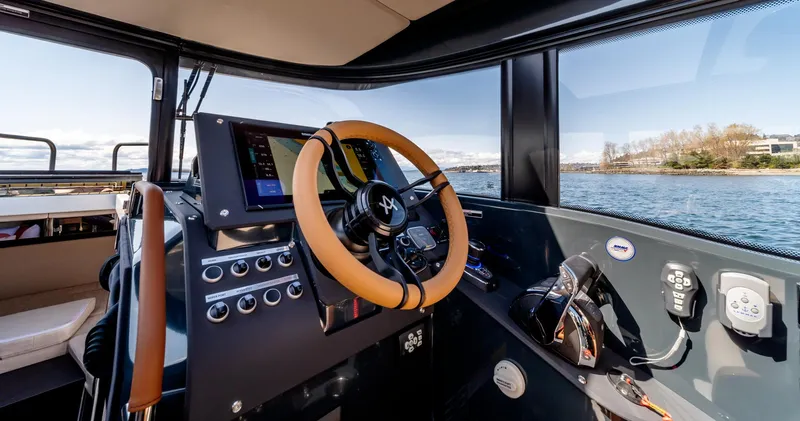 Slide: The Image of 2023 Arksen 30 boat cockpit with modern controls and steering wheel, overlooking water. - 31