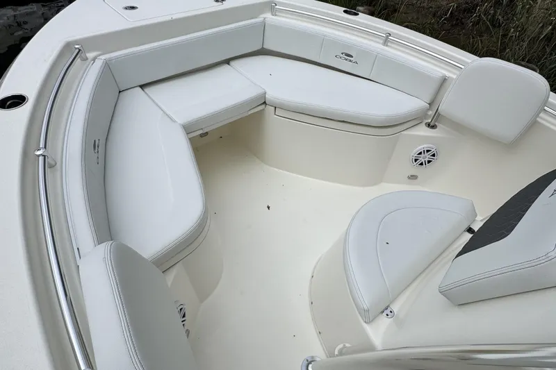 Slide: The Image of 2026 Cobia 220 Center Console boat with white cushioned seating and stainless steel railings. - 13