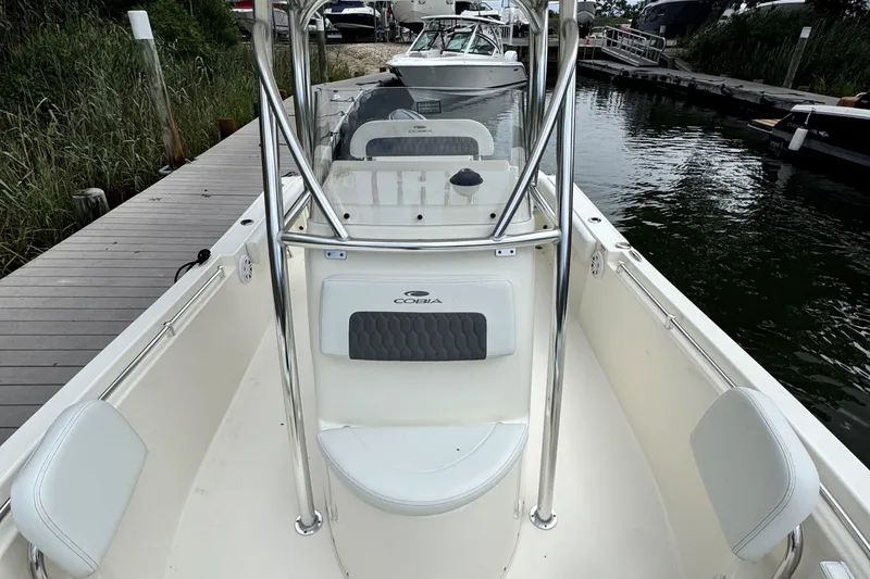 Slide: The Image of 2026 Cobia 220 Center Console boat docked, featuring sleek design and spacious seating. - 15
