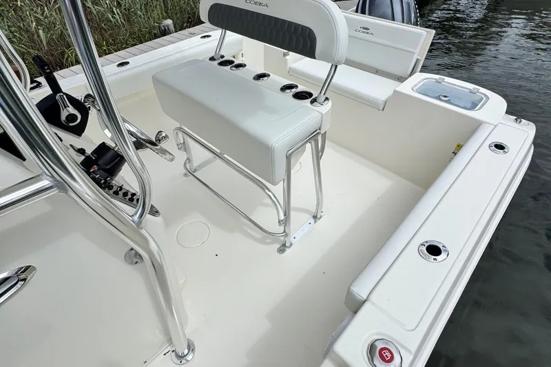 Slide: The Image of 2026 Cobia 220 Center Console boat interior with seating and rod holders. - 16