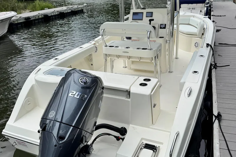 Slide: The Image of 2026 Cobia 220 Center Console boat docked, featuring a powerful 200 HP engine. - 5
