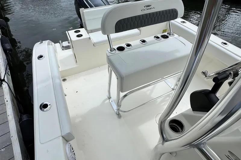 Slide: The Image of 2026 Cobia 220 Center Console boat interior with seating and rod holders. - 7