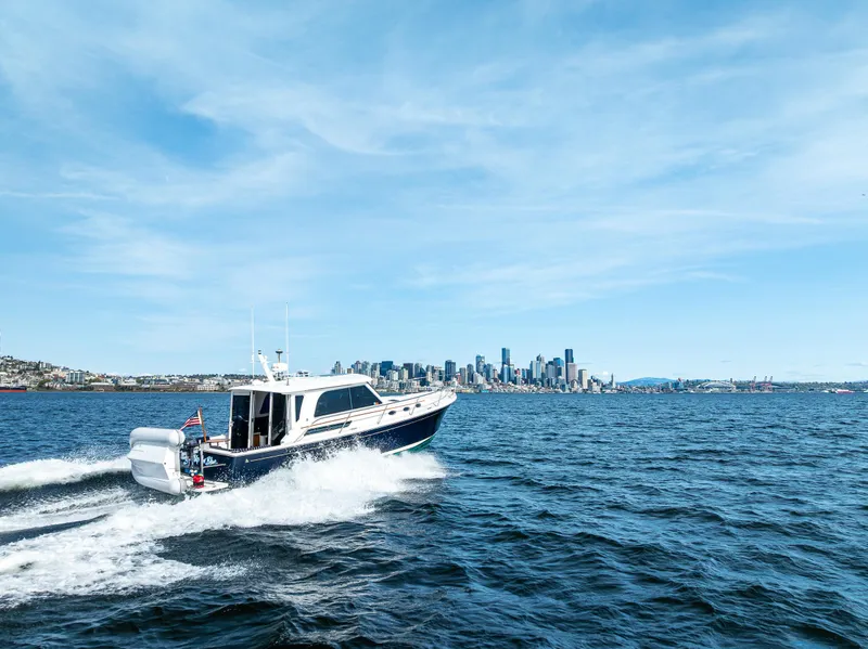 Slide: The Image of 2013 Back Cove 37 cruising on open water with city skyline in background. - 13
