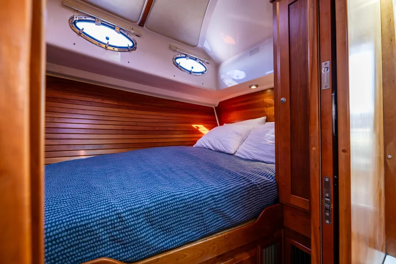 Slide: The Image of Cozy cabin interior of 2013 Back Cove 37 yacht with wooden paneling and blue bedding. - 19