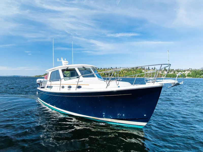 Slide: The Image of 2013 Back Cove 37 boat cruising on a sunny day, blue water and sky backdrop. - 3