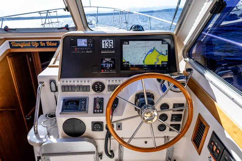 Slide: The Image of Helm of 2013 Back Cove 37 boat with navigation screens and wooden steering wheel. - 31