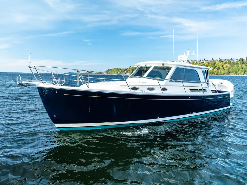 Slide: The Image of 2013 Back Cove 37 boat cruising on open water under a clear blue sky. - 5