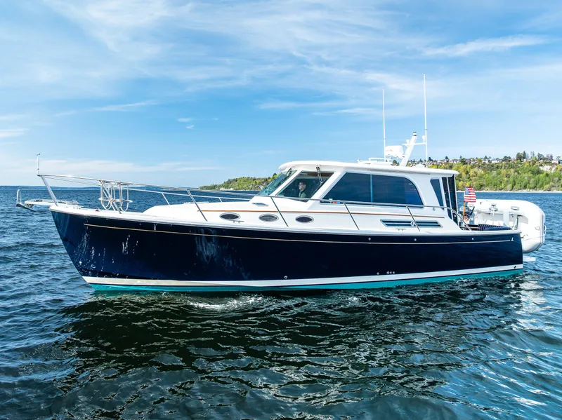 Slide: The Image of 2013 Back Cove 37 boat cruising on open water under a clear blue sky. - 6
