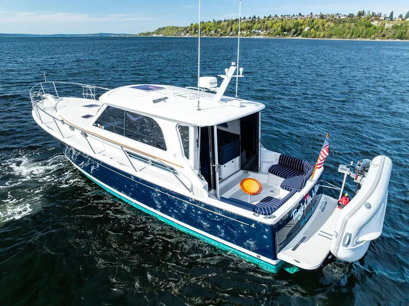 Slide: The Image of 2013 Back Cove 37 boat cruising on open water, featuring sleek design and spacious deck. - 8