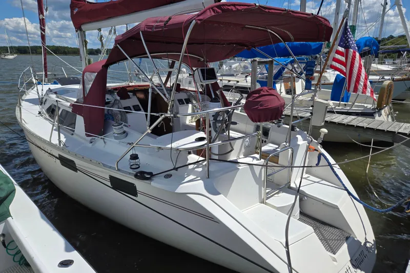 Slide: The Image of Sailboat docked at marina, 1992 Hunter 35.5 model, featuring maroon canopy and American flag. - 0