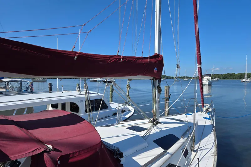 Slide: The Image of Sailboat Hunter 35.5, 1992 model, docked in a serene marina with clear blue skies. - 1