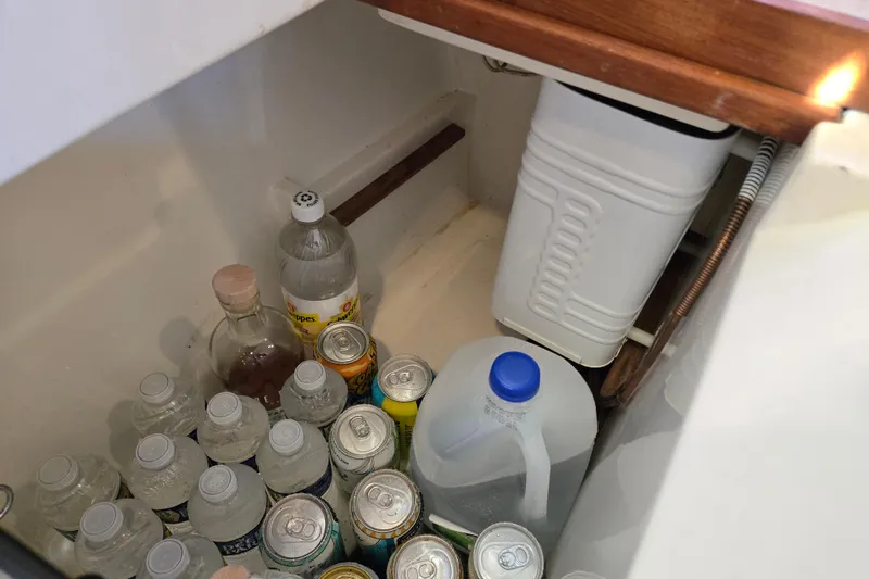 Slide: The Image of Storage compartment with assorted bottles and cans on a 1992 Hunter 35.5 model. - 11