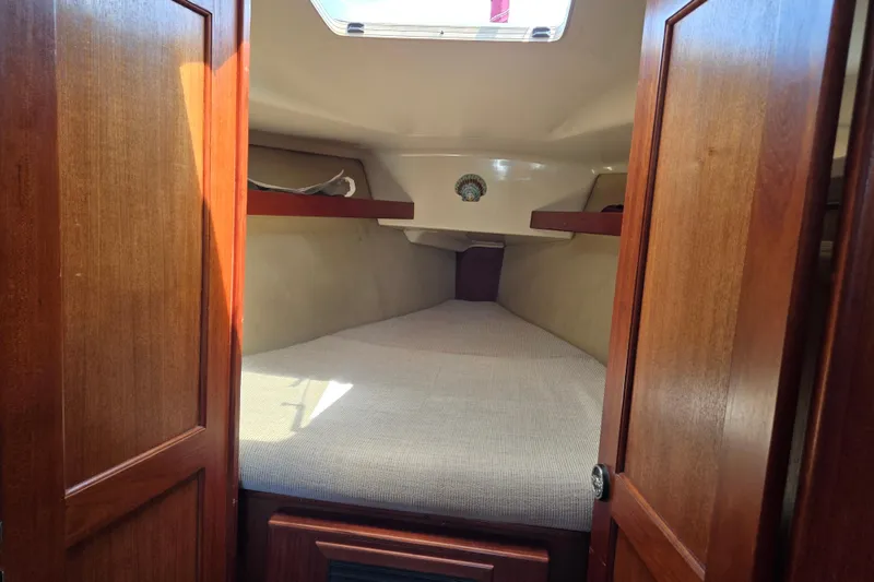 Slide: The Image of Cozy cabin interior of 1992 Hunter 35.5 sailboat with wooden doors and bedding. - 14
