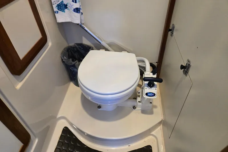 Slide: The Image of Marine toilet in a 1992 Hunter 35.5 sailboat bathroom, featuring a manual pump system. - 18